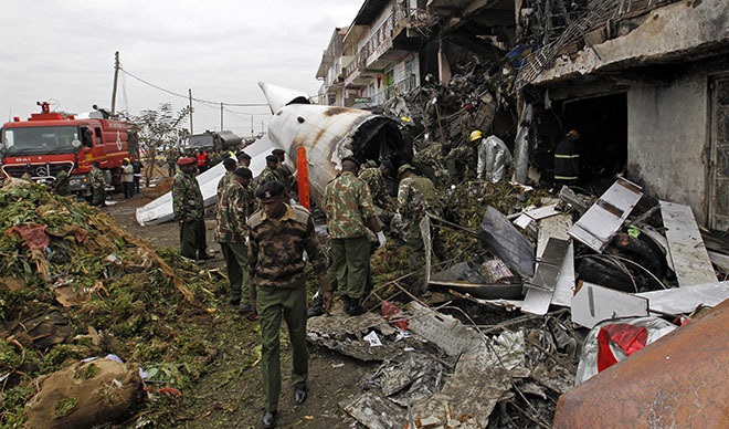 Security personnel stand at the site of the wreckage of a cargo plane that crashed into a commercial building on outskirts of Nairobi